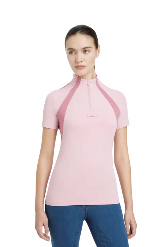 Woman wearing a pink short-sleeve top with a collar on a white background