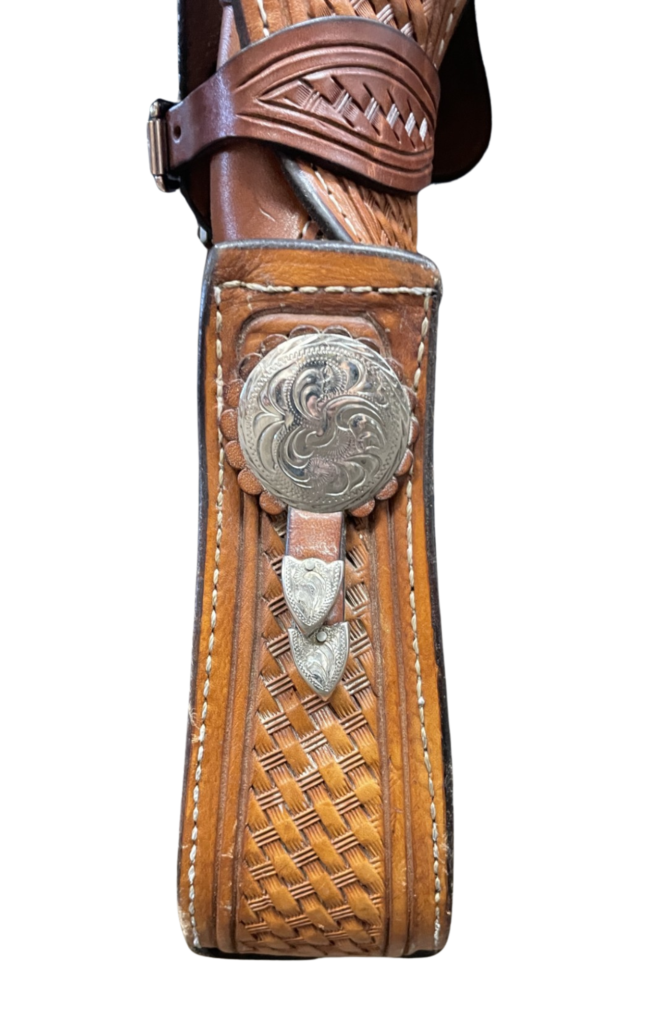 Close-up of a brown leather gun holster with decorative metal concho on a white background