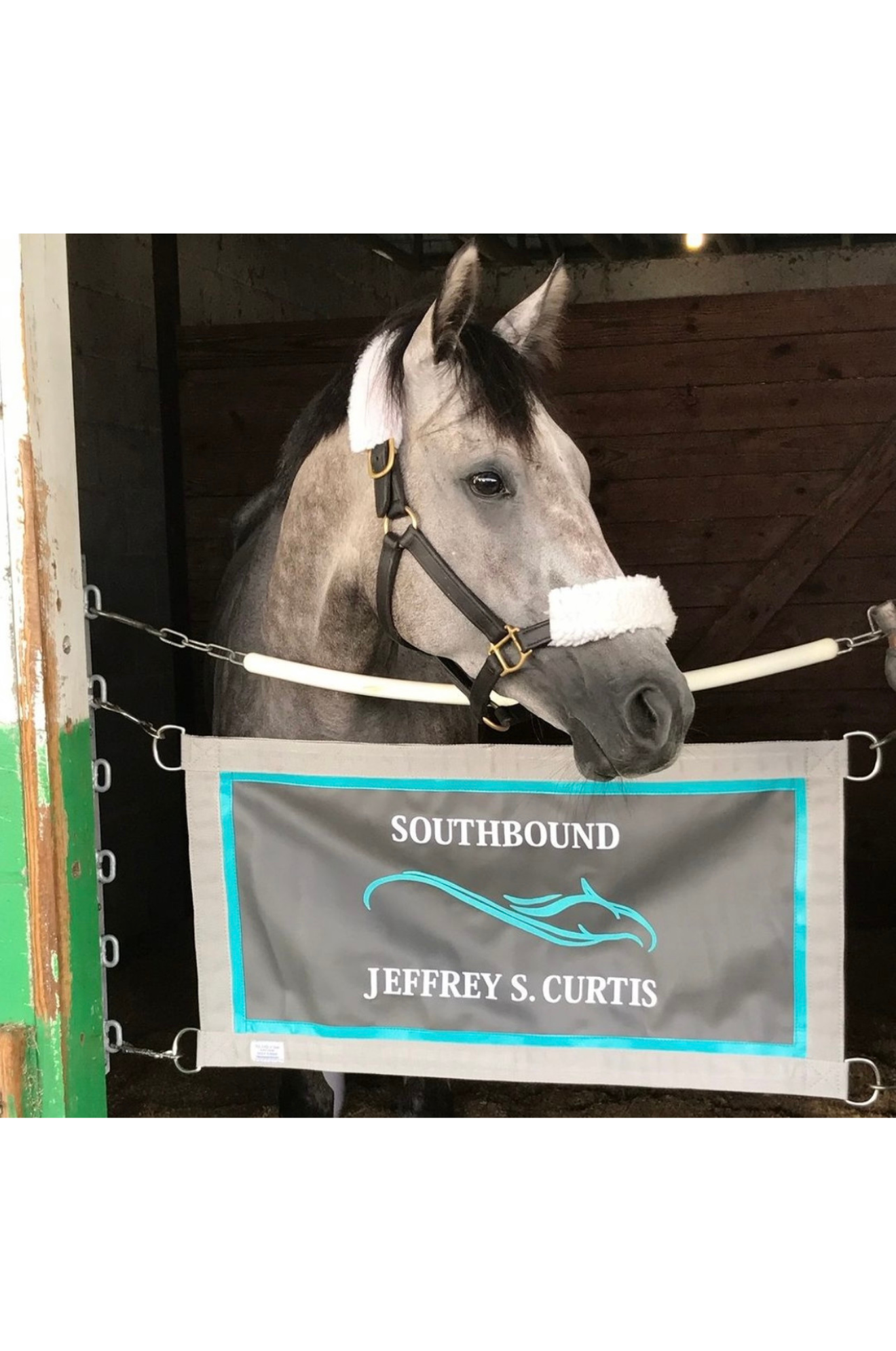 A custom stall guard with a solid blue background, white boarder and piping, displaying the text 'Henley C. Fletcher'.