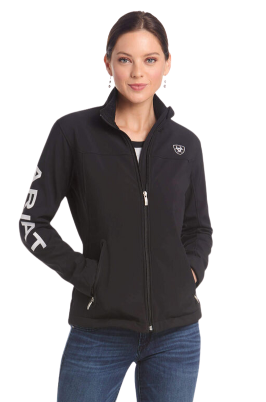 A woman wearing a black softshell jacket with the text 'TEAM' on the sleeves and a logo on the chest.
