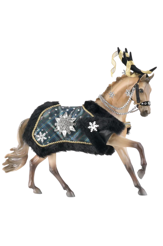 A model horse with a warm golden buckskin coat, dressed in a black and silver plaid blanket with snowflake patterns and gem-studded reins.