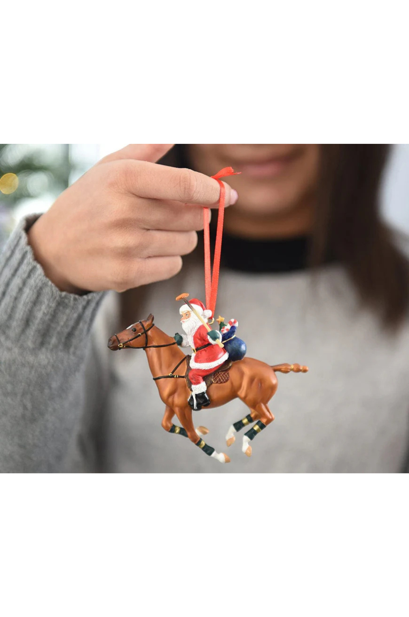 A decorative Santa ornament riding a chestnut polo pony with a mallet in hand, designed for gift wrapping.