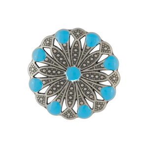 A circular silver-toned filigree brooch or pin featuring a central turquoise blue gemstone and eight surrounding turquoise blue stones set in an ornate openwork floral pattern, shown on a plain white background.