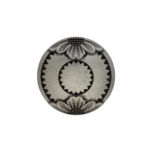 A round silver-toned metal button with a Southwestern-style geometric design featuring a central sunburst and petal motifs.