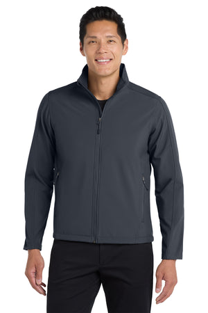 A man wearing a gray softshell jacket with a zip-through cadet collar, chin guard, and front zippered pockets.