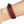 Red and black leather bracelet on a wrist against a white background