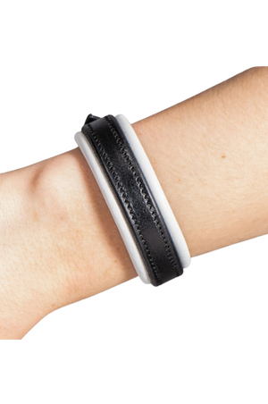 Black and white textured wristband on a wrist against a white background