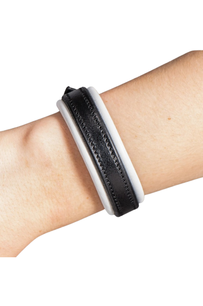 Black and white textured wristband on a wrist against a white background