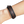 Close-up of a wrist wearing a brown leather bracelet on a white background