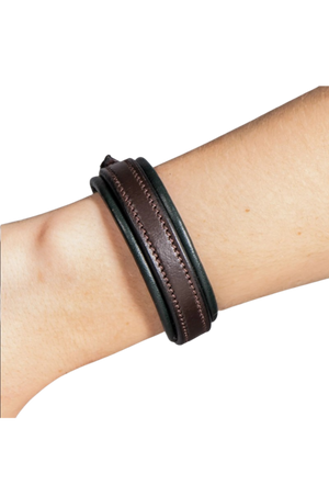 Close-up of a wrist wearing a brown leather bracelet on a white background