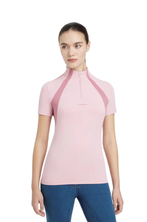 Woman wearing a pink short-sleeve top with a collar on a white background