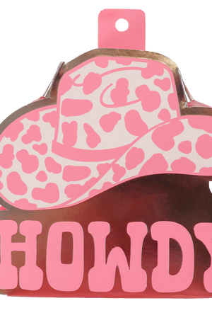 A bath sponge with a cow pattern and a pink bow.