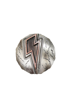 A brown leather saddle with cutout skirt, braided strings, and lightning bolt conchos, designed for barrel racing.