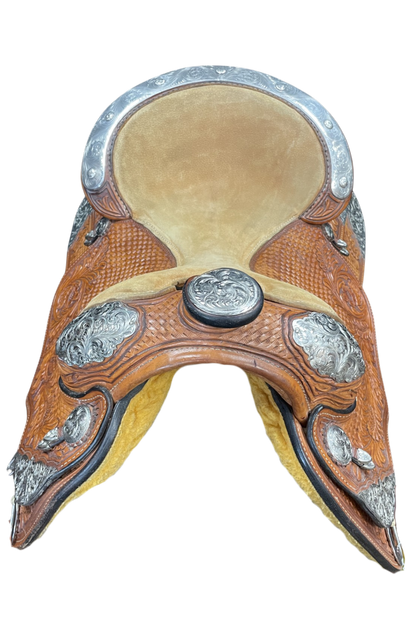 Decorative horse saddle with leather and metal details on a white background