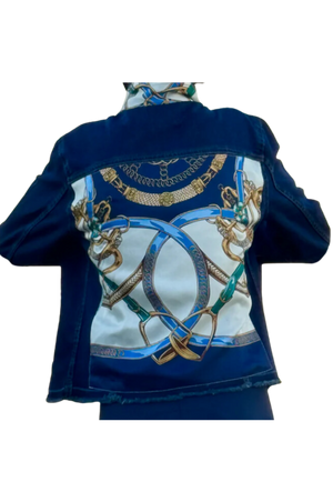 The image displays the back view of a blue denim jacket with a decorative pattern featuring gold and white elements.