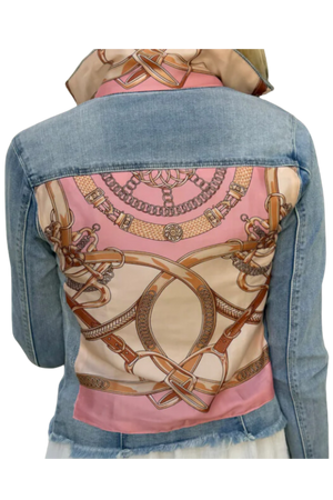 The back view of a denim jacket with a pink and beige geometric pattern design on the upper back area.