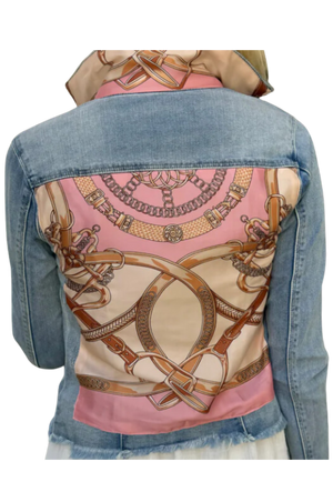 The back view of a denim jacket with a pink and beige geometric pattern design on the upper back area.