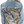 The back view of a denim jacket with a pink and beige geometric pattern design on the upper back area.