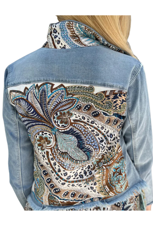 The back view of a denim jacket with a pink and beige geometric pattern design on the upper back area.