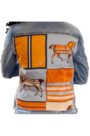 The back view of a denim jacket with a pink and beige geometric pattern design on the upper back area.