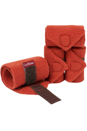 A set of red horse bandages with brown straps.