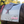 A gray custom embroidered saddle pad with pink embroidery on the sides.