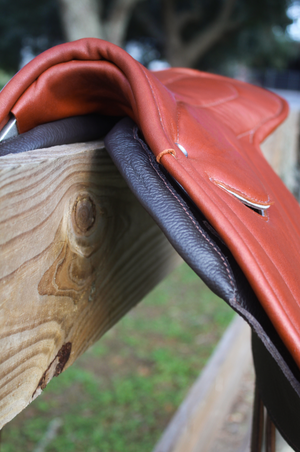 A brown leather exercise saddle with a lightweight aluminum tree, designed for thoroughbred horses.