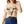 A woman wearing a beige t-shirt with a longhorn watercolor design, paired with blue jeans.