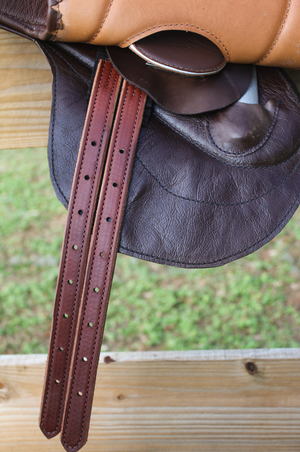 A brown leather exercise saddle with a lightweight aluminum tree, designed for thoroughbred horses.