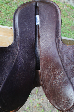 A brown leather exercise saddle with a lightweight aluminum tree, designed for thoroughbred horses.