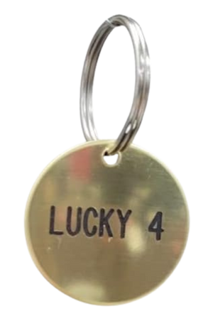 A round brass tag with the text 'LUCKY 4' engraved on it, attached to a keyring.
