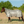 A white horse fly sheet with neck cover, featuring adjustable straps and leg straps, designed to protect the horse from insects and UV rays.