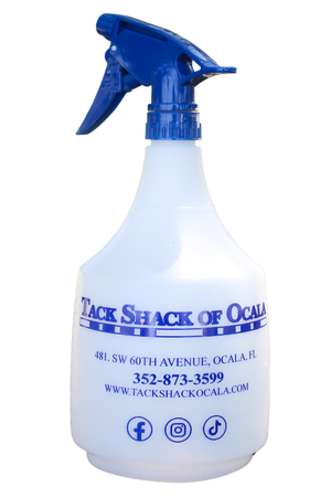 A white spray bottle with blue text and a blue trigger spray head. The text includes the name 'TACK SHACK OF OCALA' and contact information.