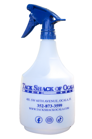 A white spray bottle with blue text and a blue trigger spray head. The text includes the name 'TACK SHACK OF OCALA' and contact information.