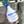 A white spray bottle with blue text and a blue trigger spray head. The text includes the name 'TACK SHACK OF OCALA' and contact information.