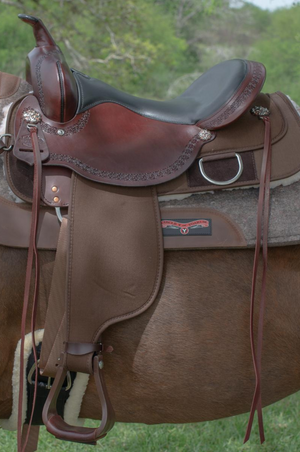 A brown Circle Y Magnolia Cordura Trail saddle with stainless hardware and copper flower conchos.