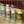 A wire spray bottle holder designed to hang over stalls, fences, or gates.