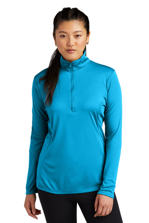 A woman wearing a blue long-sleeved pullover with a quarter zipper at the neck.