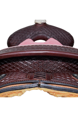 A brown roper saddle with black iron sun conchos, a pink suede seat, and a nylon horn wrap. It features walnut finish with hand-tooling and a baby powder holder.