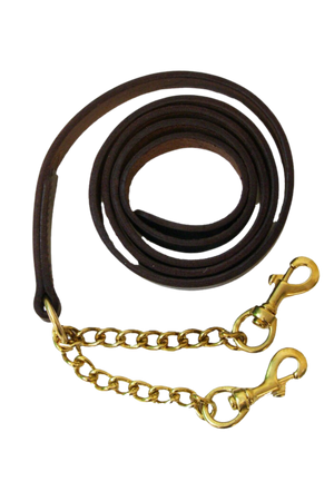 A brown leather horse show shank with brass hardware, coiled and laid out with a metal chain attached for bit attachment.