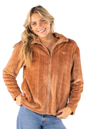 A smiling blonde woman wearing a brown textured zip-up fleece jacket and blue jeans, photographed against a plain white background.