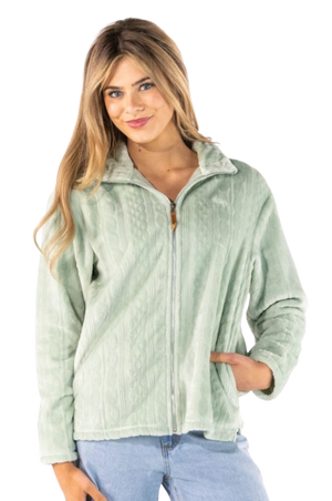 A woman wearing a sage green zip-up fleece jacket with a textured knit pattern, paired with light blue jeans, against a solid white background.