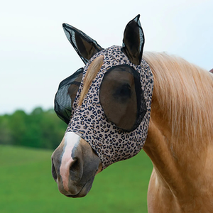 Horse wearing a protective fly mask with a leopard print pattern in an outdoor setting.