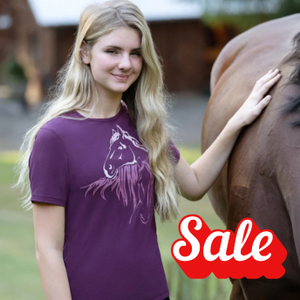 Woman in a purple shirt with a horse graphic standing next to a horse, with a 'Sale' label.