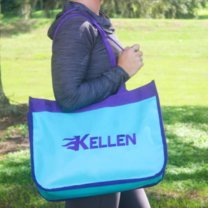 Person holding a blue and purple bag with 'Kellen' branding outdoors.