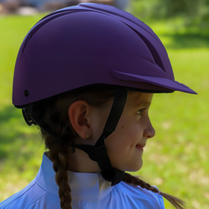 Child wearing a purple helmet in an outdoor setting