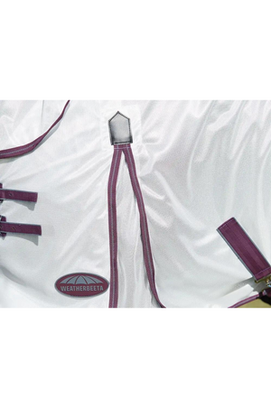 A horse wearing a white mesh sheet with red and grey trim, designed for fly protection and breathability with features such as adjustable leg straps and a large tail flap.