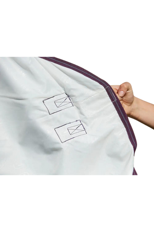 A horse wearing a white mesh sheet with red and grey trim, designed for fly protection and breathability with features such as adjustable leg straps and a large tail flap.