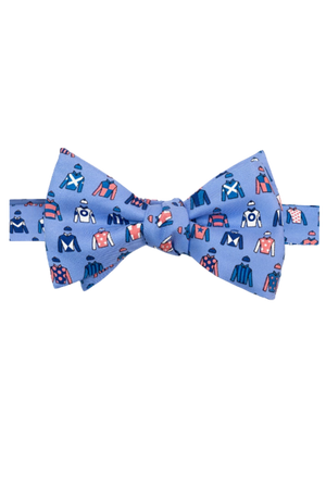 A blue bow tie with a pattern of race horse jockeys in different colors.