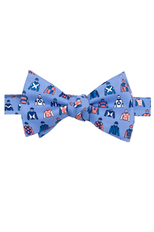 A blue bow tie with a pattern of race horse jockeys in different colors.